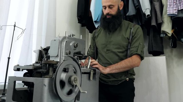 A Tailor works on his eyelet buttonhole machine.