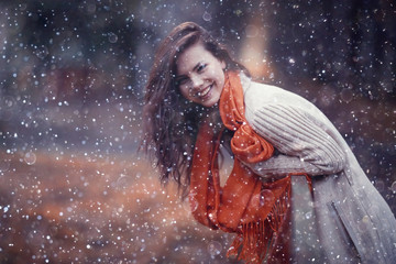 Winter portrait of young girl with snowflakes in the air