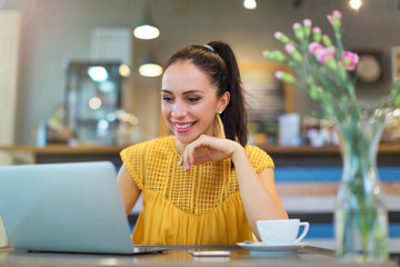 Woman using laptop in cafe
