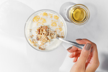 Spoonful of morning oatmeal with honey and dried fruits, taken from above