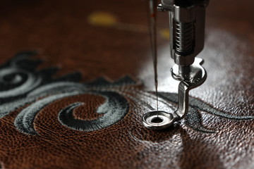 Multilayer embroidery on brown leatherette with embroidery machine - close up with needle up -...
