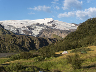 Tents in the campsite of Torsmerk National Park against the background of the volcano Eyjafjallajokull, Iceland