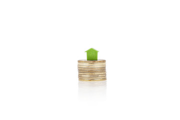 Green house on coins - real estate concept