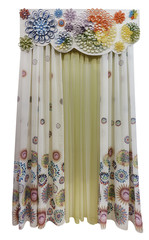 Bright interior design, curtains with a large pattern, yellow translucent tulle and hard figured pelmet with voluminous applique in the form of colorful colors
