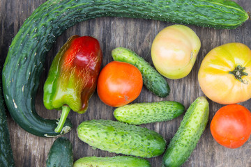 Fresh vegetables on old wooden table. Organic cucumber, tomatoes, pepper. Concept of healthy eating