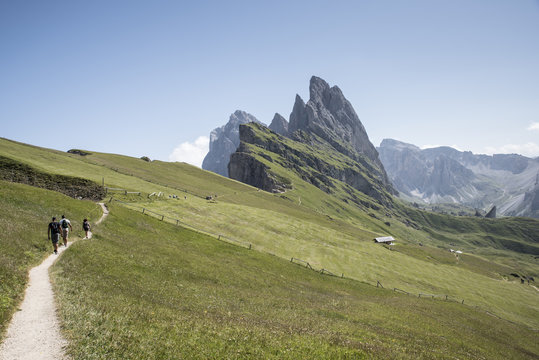 tre turisti camminano sul sentiero delle alpi italiane