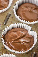 Raw chocolate cup cakes mixture in the cup cakes papers ready for baking