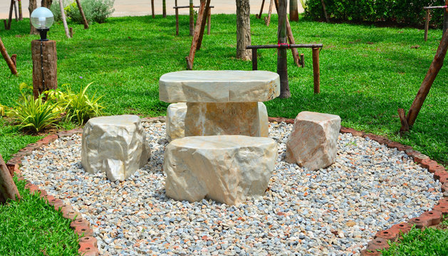 Marble Chair On Pebbles In Garden Have Grass  Background.