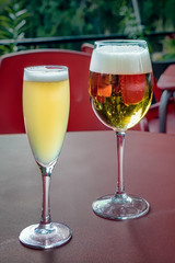 Glasses of beer and lemon beer on outdoors bar table.