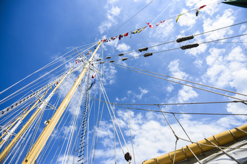 Rigging a sailboat on a beautiful sunny day in the blue sky. - obrazy, fototapety, plakaty