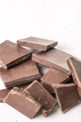 Slices of cooking chocolate on the white marble background table