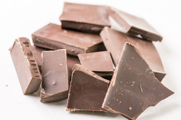 Slices of cooking chocolate on the white marble background table