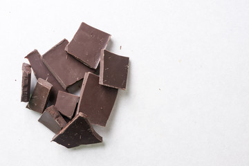 Slices of cooking chocolate on the white marble background table