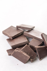 Slices of cooking chocolate on the white marble background table