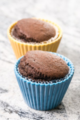 Chocolate cup cakes in the porcelain bowl on the grey granite background