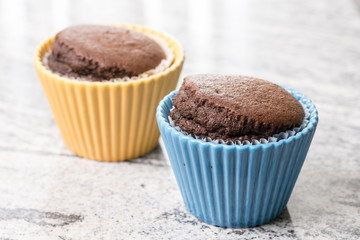 Chocolate cup cakes in the porcelain bowl on the grey granite background