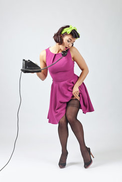 Beautiful woman in pin up style with vintage phone.