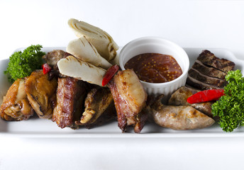 Grilled meat mix with tortilla on a white plate