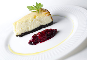 Classic cheesecake with cherry sauce on a white plate