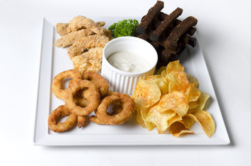 Mix of beer snacks on a white plate