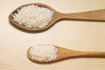 wooden spoon with rice on wooden table
