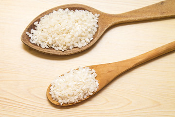 wooden spoon with rice on wooden table