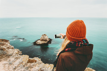 Woman taking photo by smartphone of sea landscape Travel Lifestyle concept adventure vacations outdoor