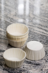 Obraz na płótnie Canvas Empty white cup cake cases containers on the grey granite marble background