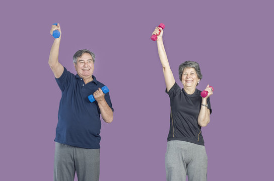 Two senior people in a gym class doing Pilates exercise lift weights over a purple background