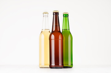 Group of brown, green, transparent longneck beer bottles 500ml, mock up. Template for advertising, design, branding identity on white wood table.