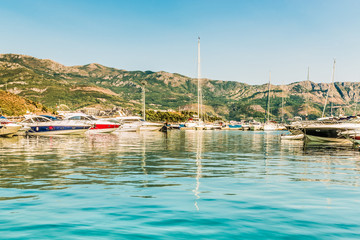 Pier for sailing yachts and boats with a view of the mountains off the coast of Budva, Budva Riviera.