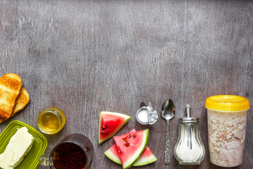 Oatmeal with watermelon, toast with butter and honey on a wooden table. The concept of a healthy breakfast