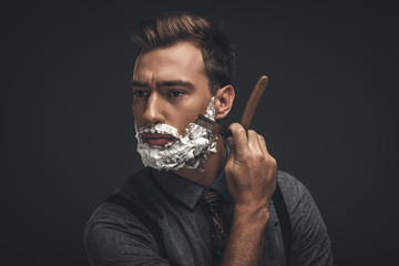 man shaving with straight razor