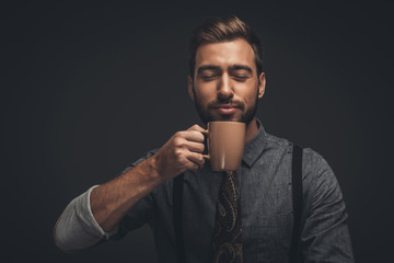 Handsome man smelling coffee