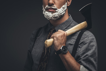 Man in shaving cream holding axe
