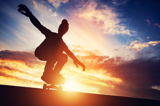 Man skateboarding at sunset.