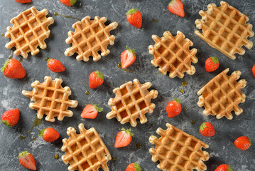 Traditional waffles with maple syrup and strawberries
