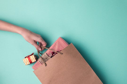 hand holding paper bag with gifts