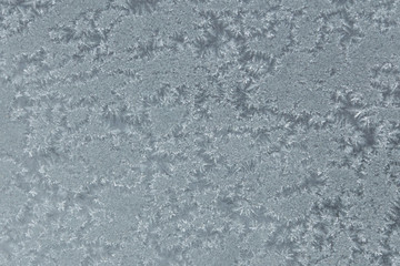 Fototapeta premium A real frosty drawing background on the frozen glass window.