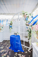 white wedding arch decorated with flowers and cloth