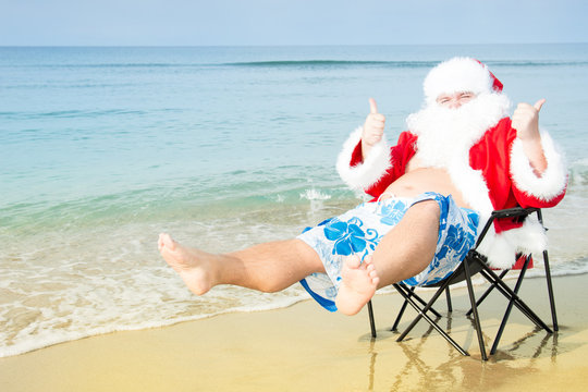 Funny Santa in shorts on the beach. 