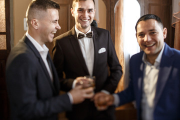 groom and his groomsmen drinking whiskey