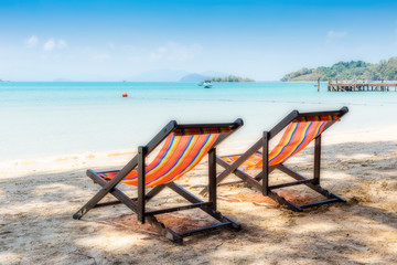 Fototapeta na wymiar Two beach chairs on idyllic tropical sand beach.