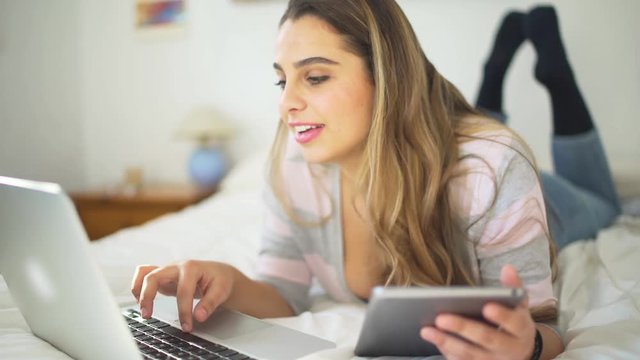 A beautiful woman studiying in the bedroom with laptop
