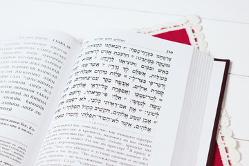 Jewish book on a white background, with red napkin. "Psalms of David". Not isolated image, place for text.Text of the Hebrew, prayer. © ksana_uk