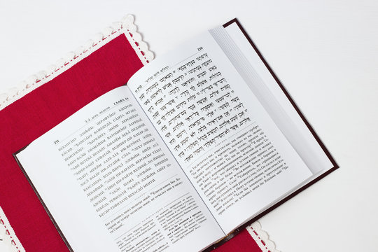 Jewish book on a white background, with red napkin. "Psalms of David". Not isolated image, place for text.Text of the Hebrew, prayer.