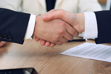 Obraz na płótnie Canvas Close up of business people shaking hands at meeting or negotiation in the office. Partners are satisfied because signing contract