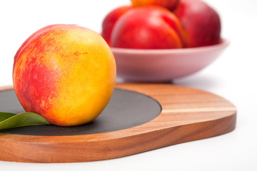 Freshly washed peach  on wooden cutting board isolated on white background