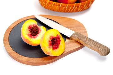 Freshly washed peach  on wooden cutting board with knife