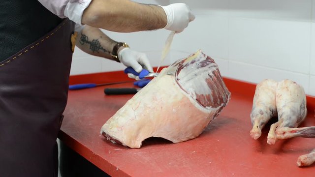 Cutting of the lamb for the preparation of meals. Butcher cut up the carcass of fresh meat.